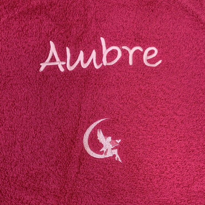 Broderie prénom Ambre avec motif fée sur serviette de bain fuchsia