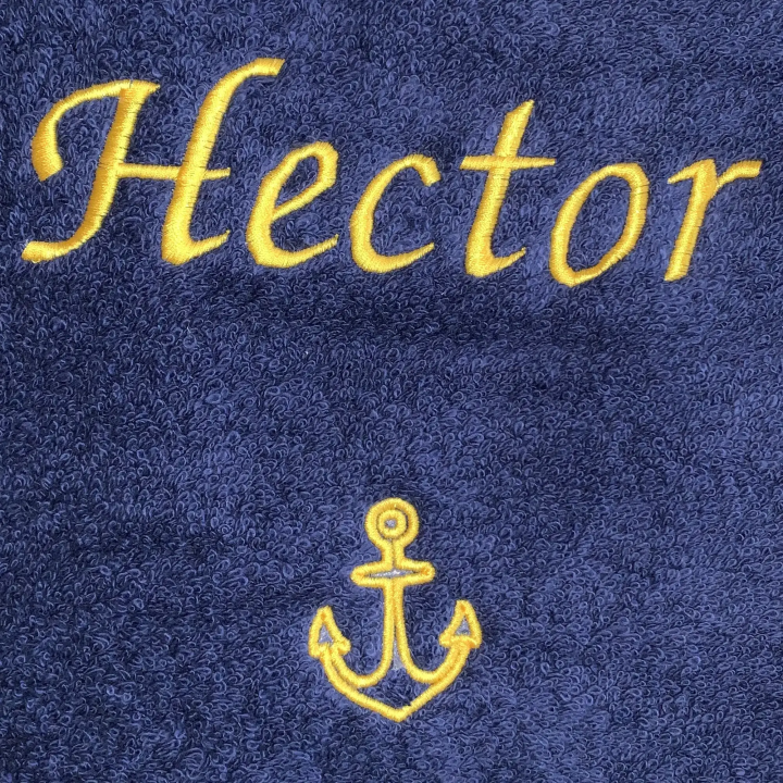 Broderie prénom Hector et motif ancre marine avec fil jaune sur linge de bain bleu marine